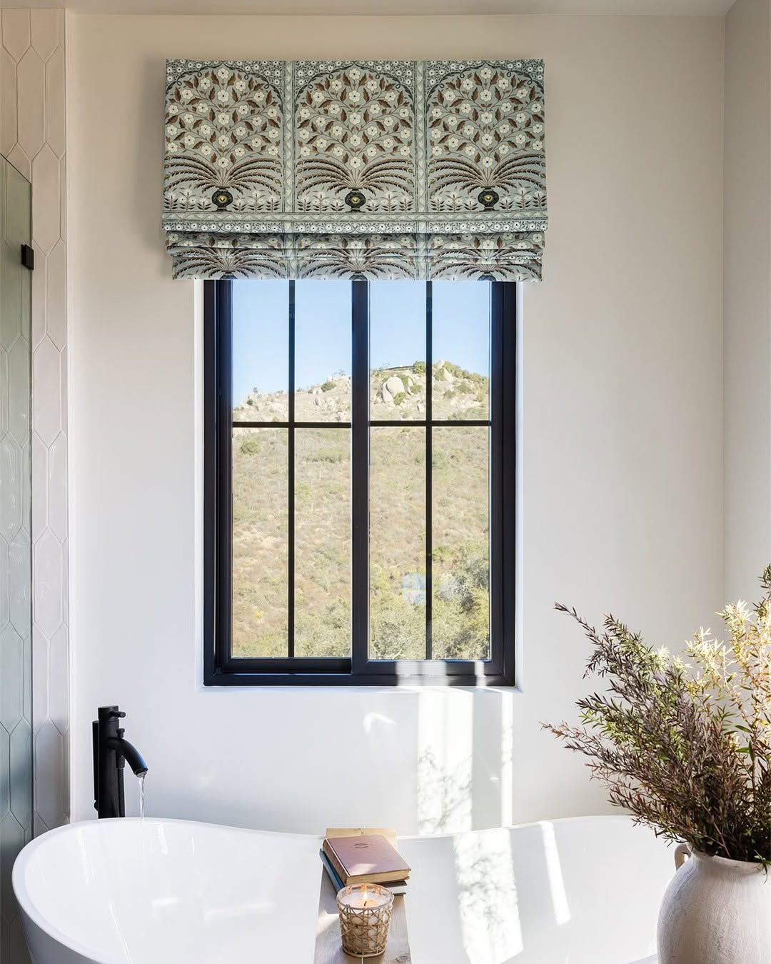 Patterned fabric Roman shades with flat fold style on a window, light filtering and blackout options available.