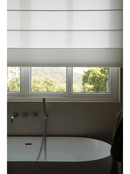 Eco-friendly sheer Roman blind in a modern bathroom with scenic green view outside, enhancing natural light and privacy