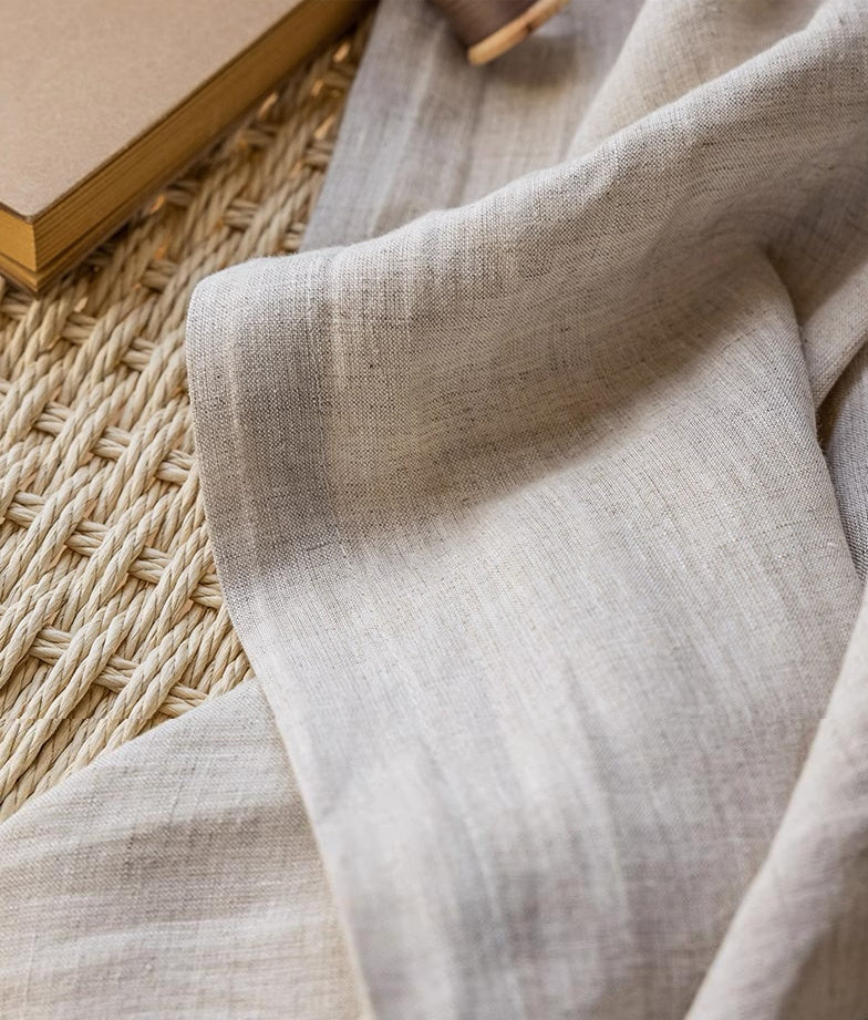 Close-up of natural linen colored drape highlighting fine texture and quality, accompanied by rustic home decor elements