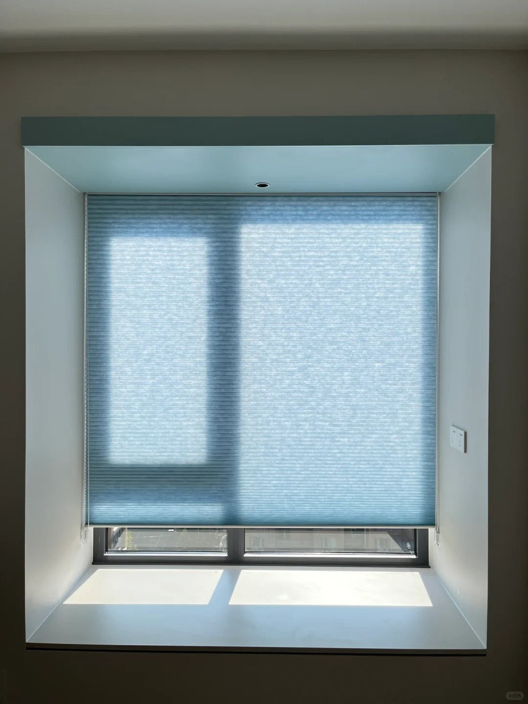 Light blue dual-cell honeycomb shades with large apertures, providing a refreshing and invigorating ambiance.