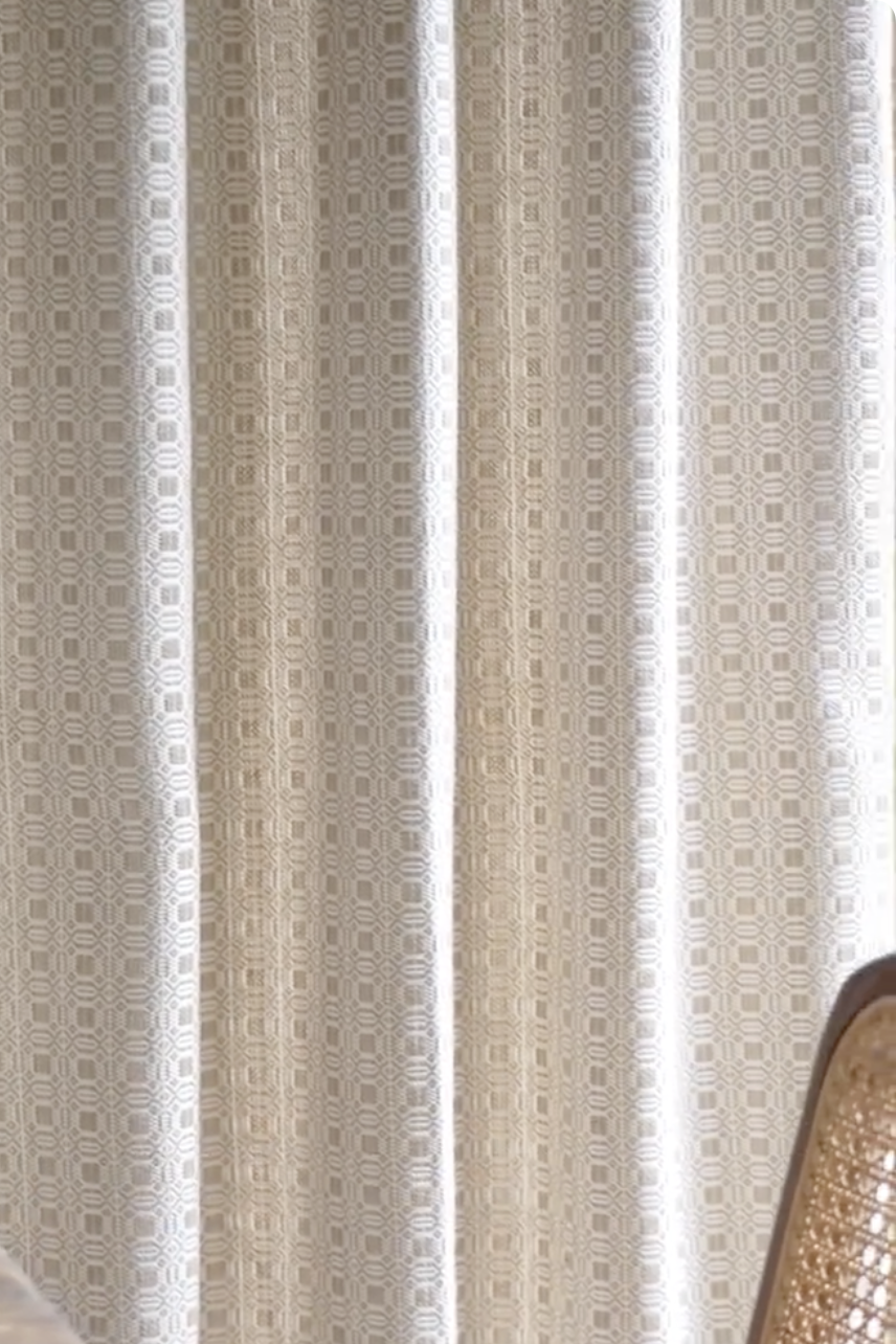 Beige vintage curtains with geometric pattern and soft light filtering through, enhancing a classic and elegant interior ambiance.