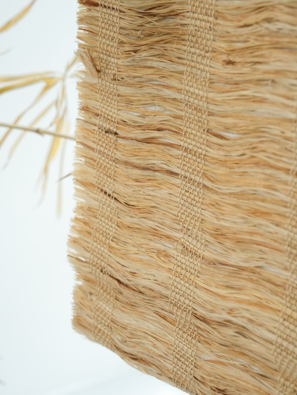 Close-up of honey-colored woven shades made from natural ramie fiber with textured weave
