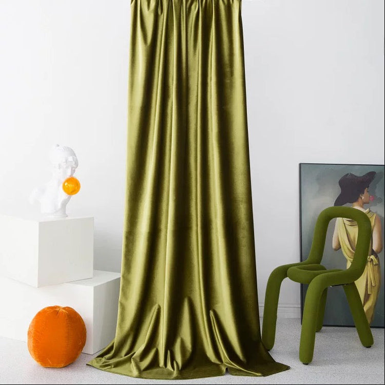 High-matte vintage green velvet drapes elegantly puddling on floor in modern living room setting