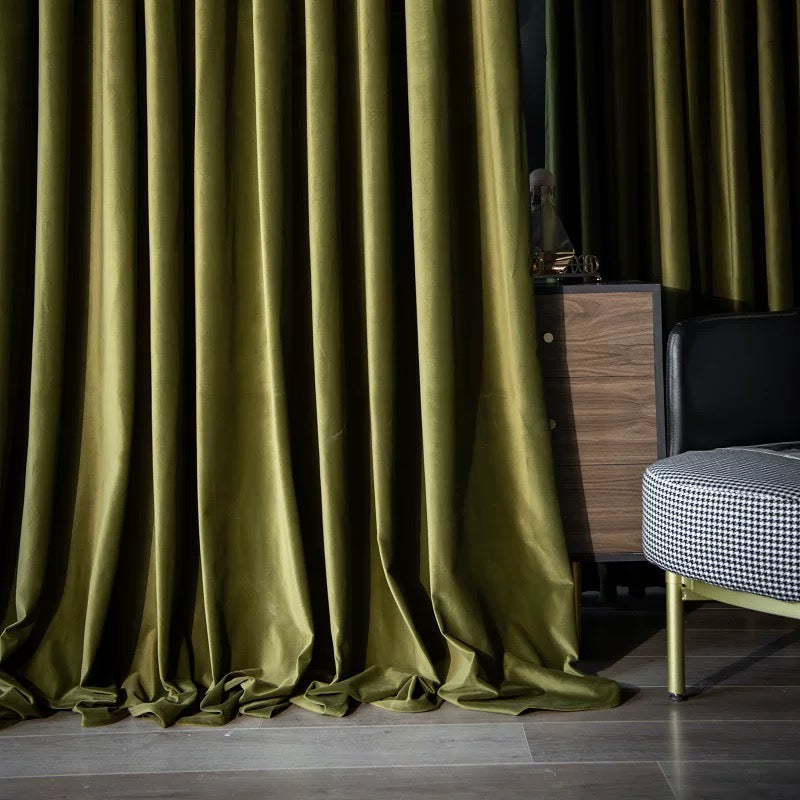 High-matte green velvet drapes elegantly pooling on floor in modern living room setting
