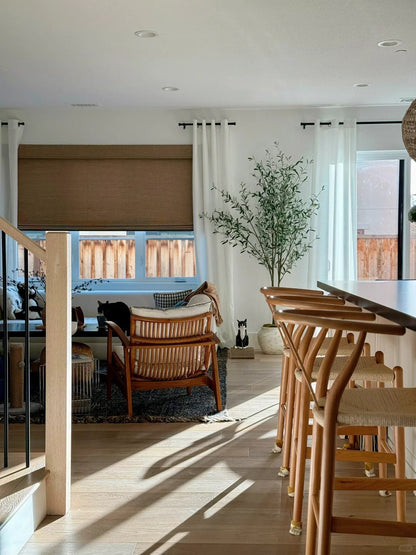 living room with bamboo roman shades on window and natural wooden furniture
