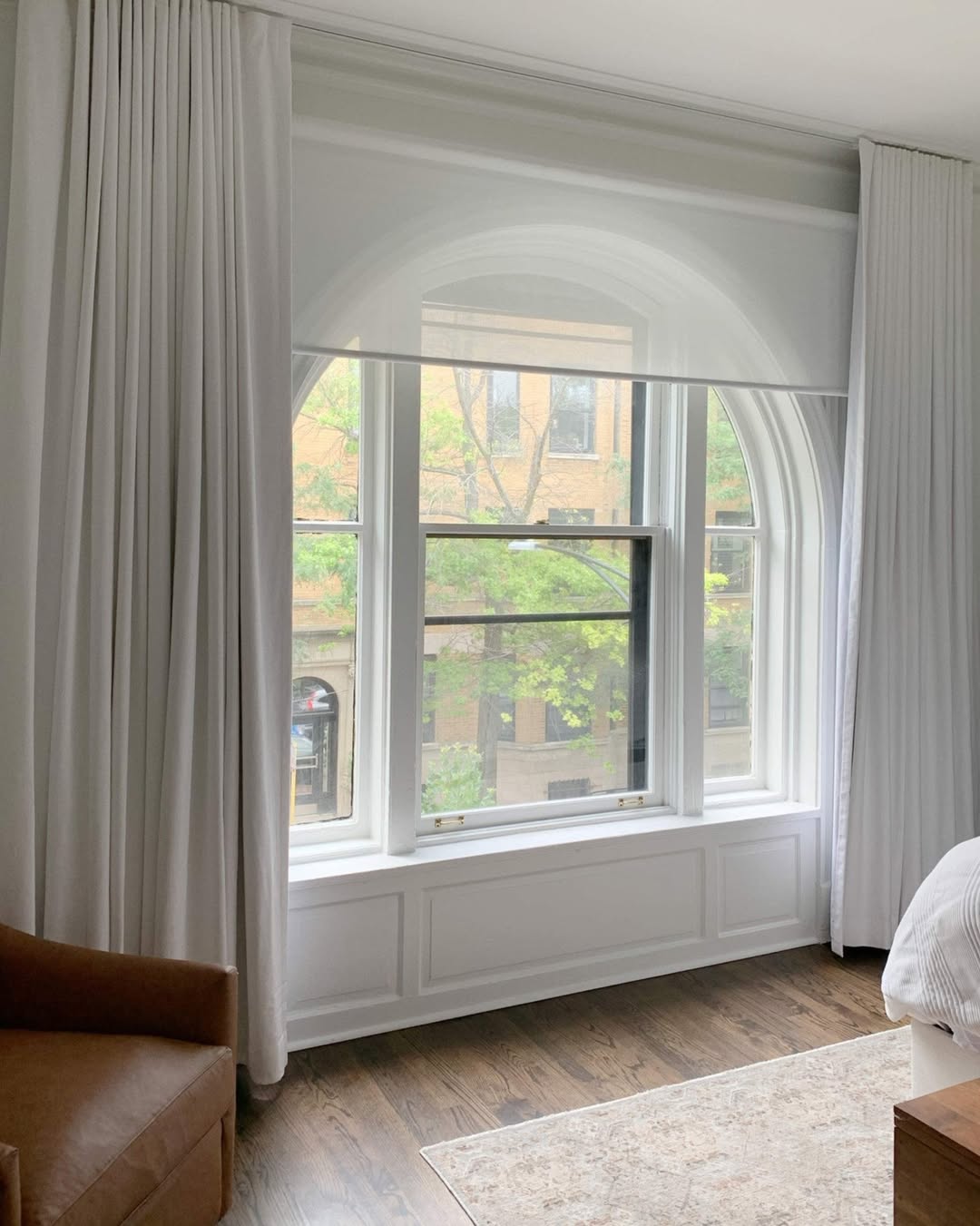 Solar shades installed on arched window, providing UV protection and modern design.
