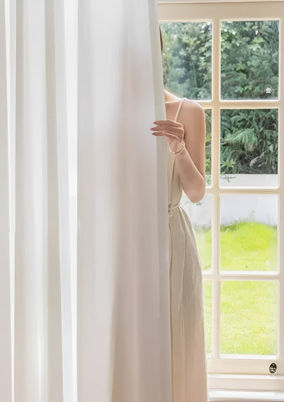 White sheer curtain providing privacy and light penetration in a stylish home setting.