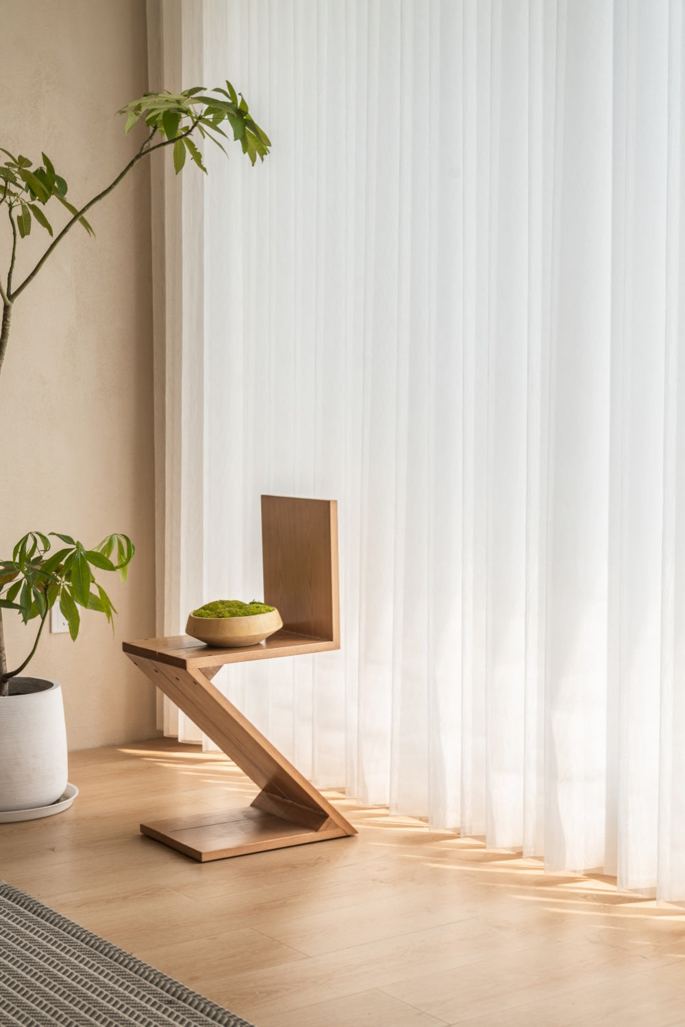  A shelf and a plant in front of a window, designed with a special fabric and sheer blend for a perfect balance of light and transparency.
