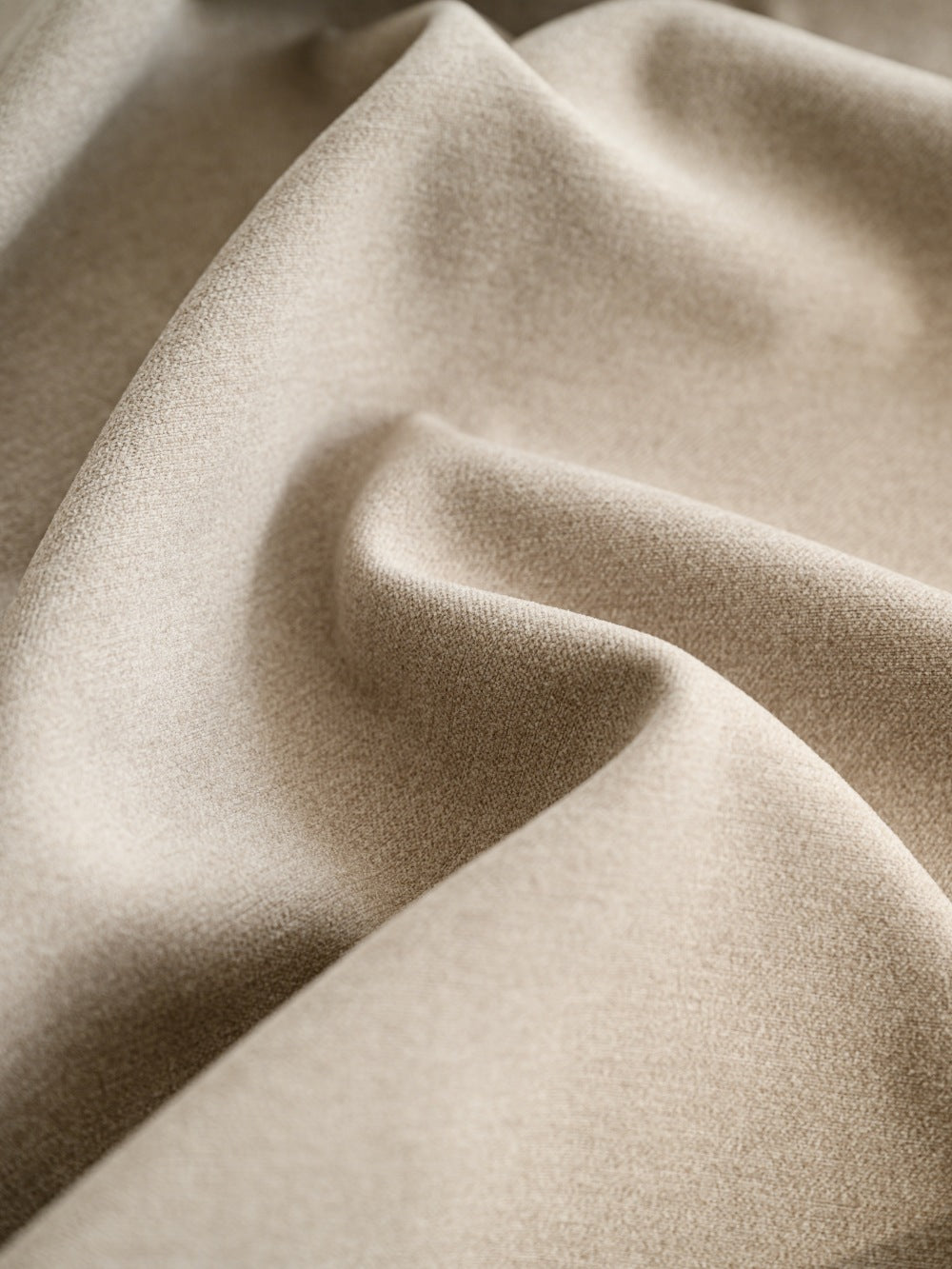 Close-up of luxurious faux cashmere texture in soft beige, ideal for blackout curtains with pleated design, offering both aesthetic appeal and practical functionality