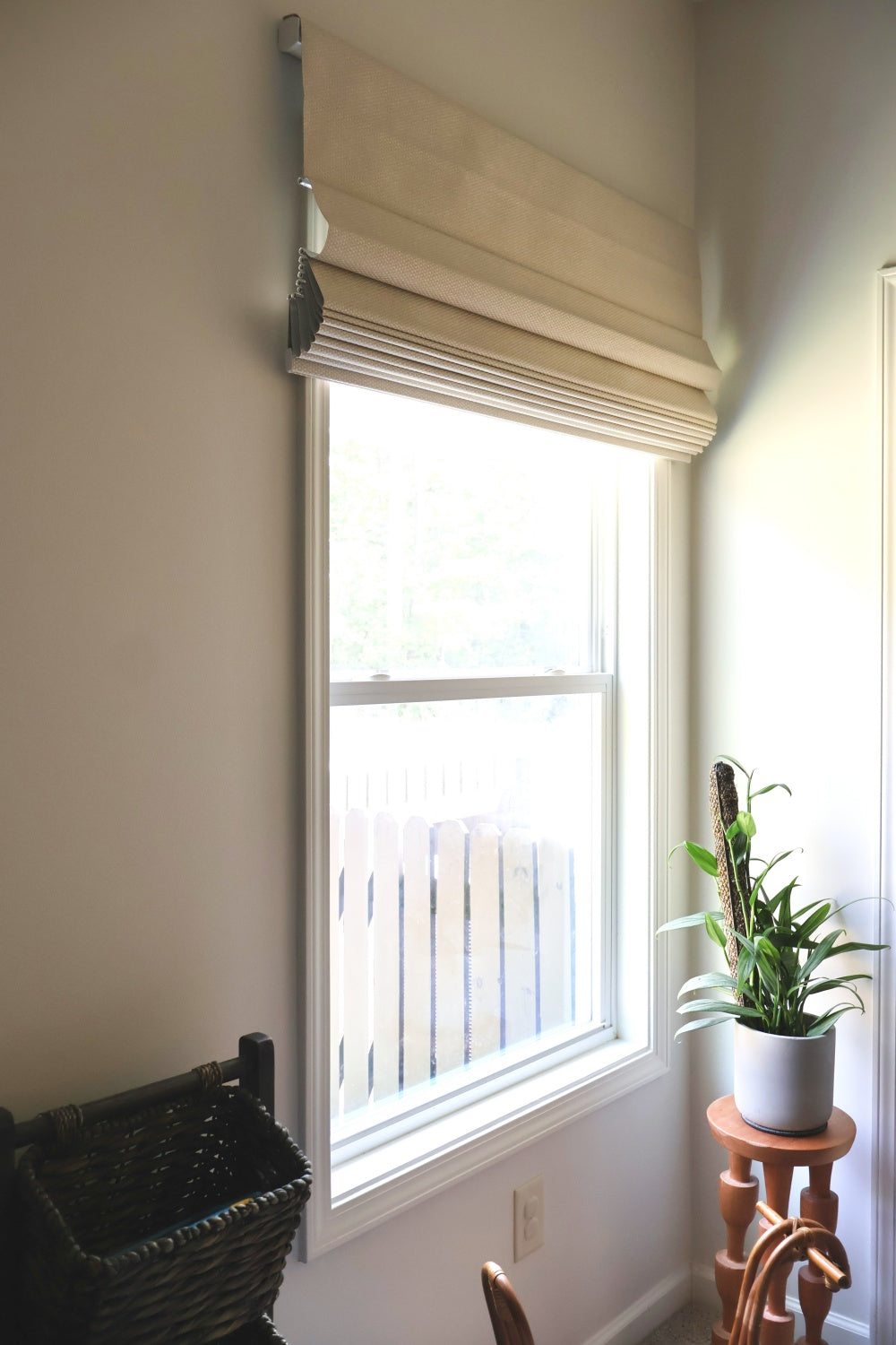  Room with chair and window, showcasing eco-friendly Roman blinds with cordless design for safety and child-friendly settings.