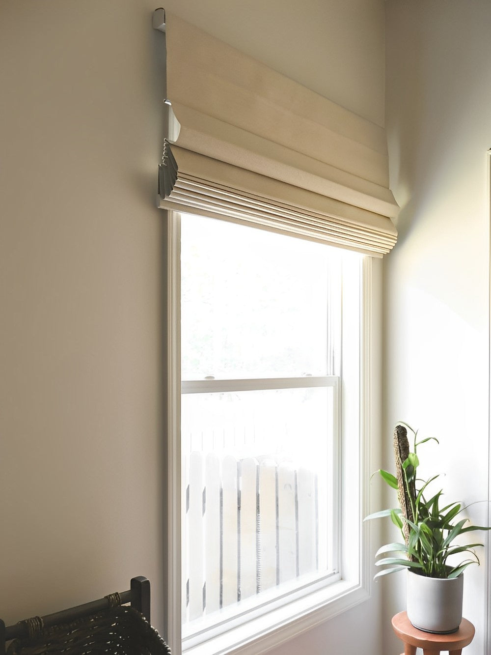 Cordless blackout Roman shades in a neutral color, installed in a brightly lit room, enhancing privacy and blocking light.