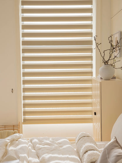 Eco-friendly zebra roller shades in a modern bedroom with natural light filtering through, featuring dual-layer of fabric for enhanced privacy and light control