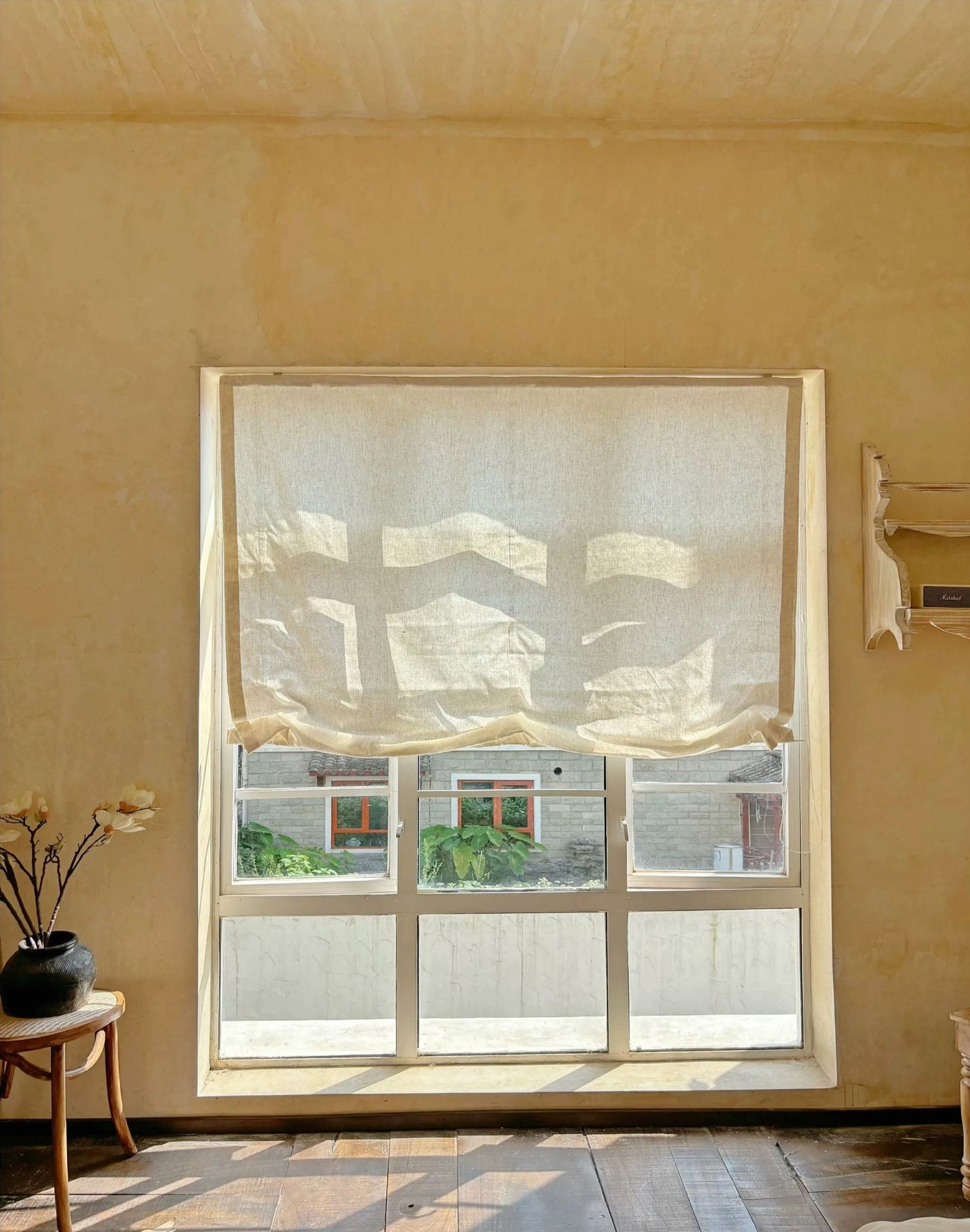 Relaxed roman shades filtering light in French-style interior.