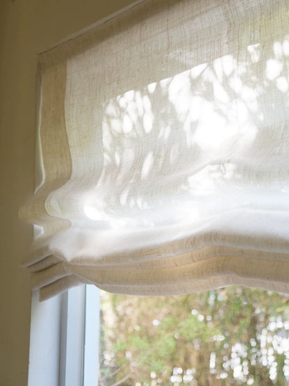 Relaxed Roman shades with light filtering, soft drapes, and graceful waves.