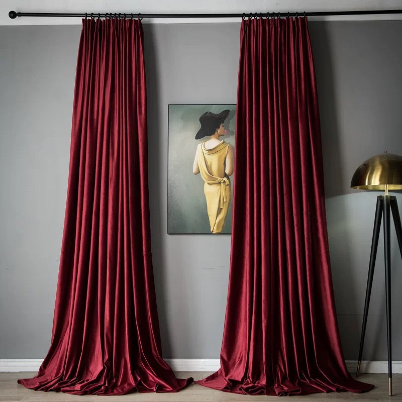 Luxurious deep red high-matte velvet drapes with a soft, vintage texture hanging in a modern living room setting