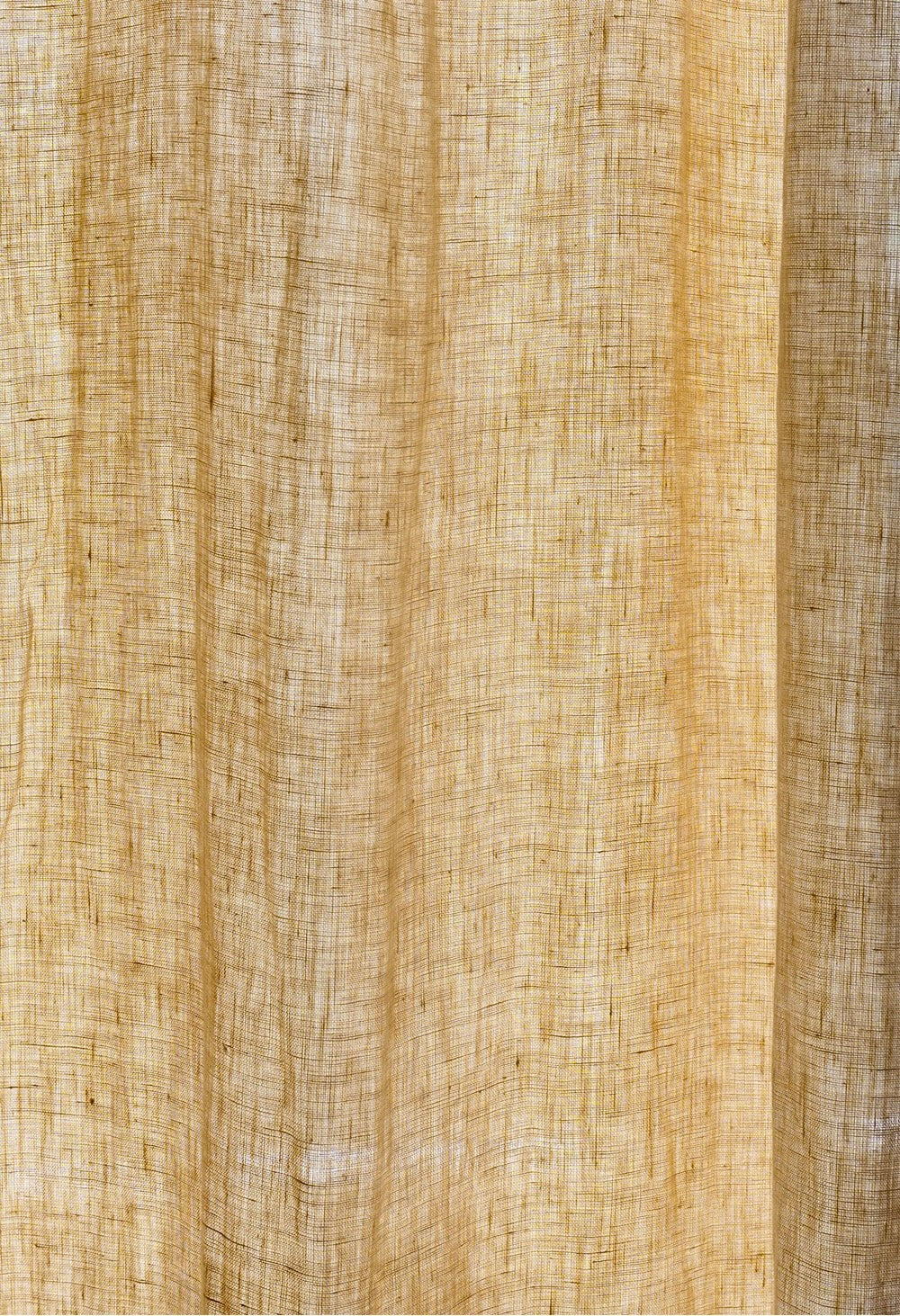Close-up of soft pale yellow pure linen pleated curtain, highlighting the fine texture and natural weave of the French-imported fabric