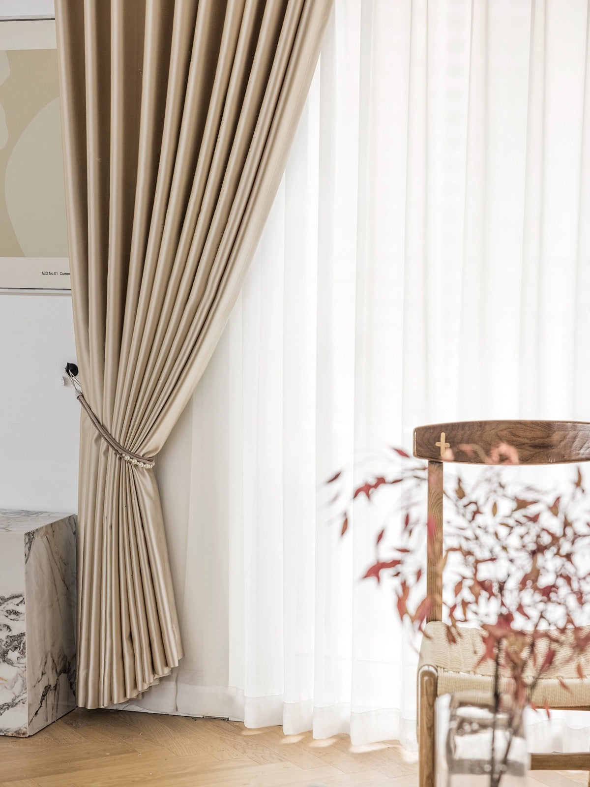 Elegant pleated beige silk drapery alongside sheer white curtains in a luxurious living room setting, emphasizing sophisticated window treatment and interior decor