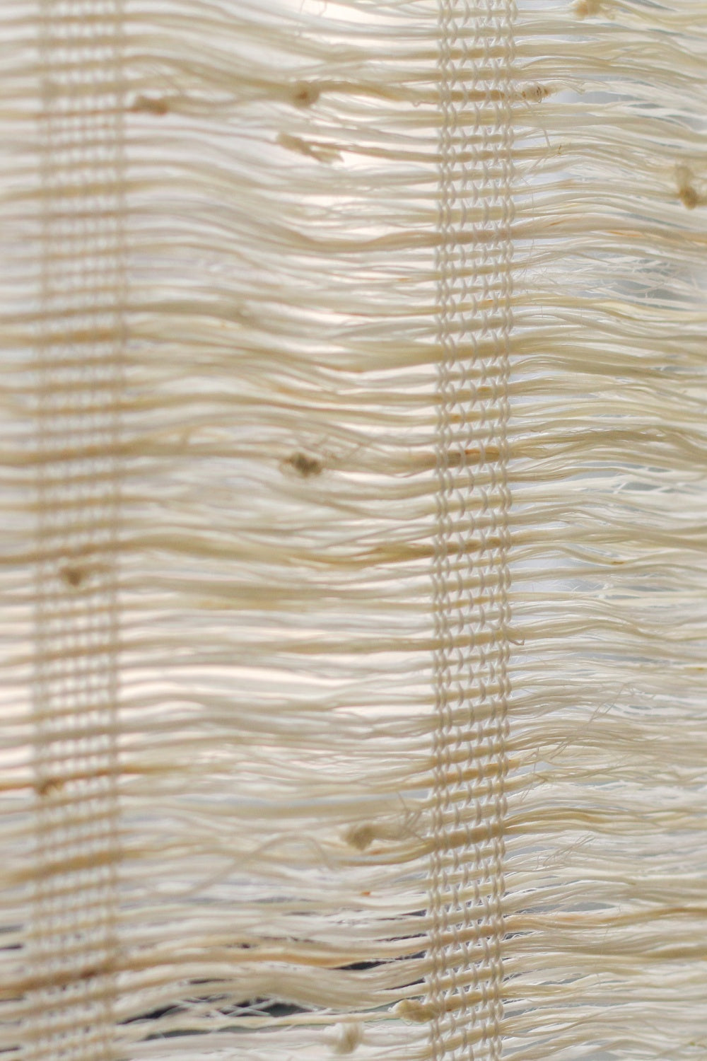 Close-up of natural almond-colored ramie woven wood shades with soft, breathable texture