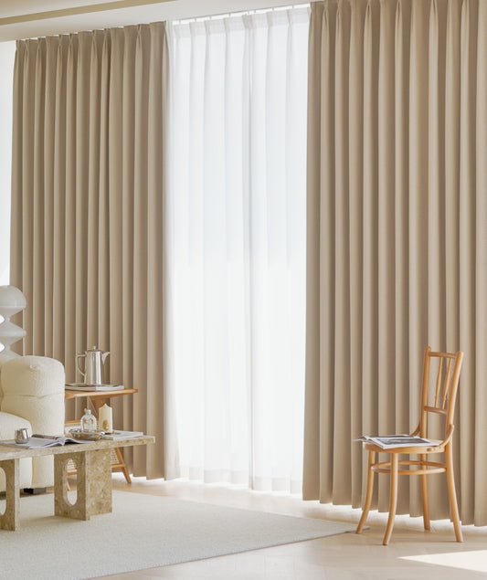 A cozy living room with a chair, featuring the elegant EaseEase Herringbone Pattern Chenille Curtain.