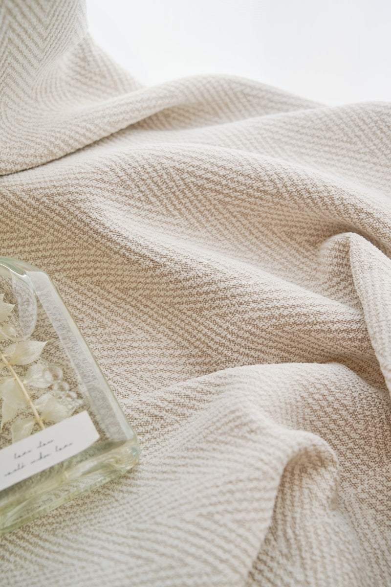 A bottle of perfume positioned on top of a EaseEase Herringbone Pattern Chenille Curtain.