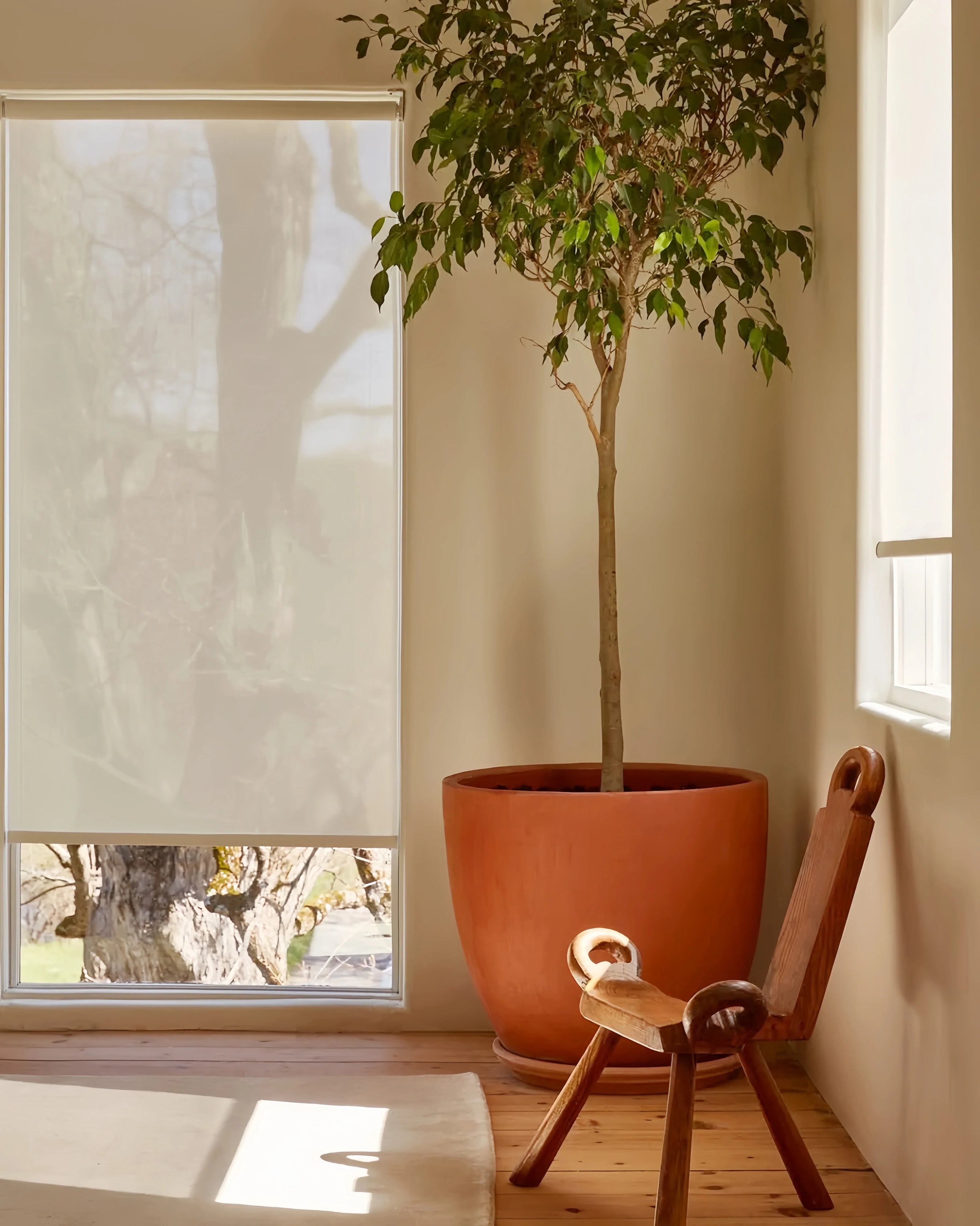 Cordless natural woven linen roller shade in a bright living room setting.