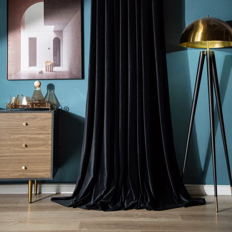 Black high-matte velvet drapes elegantly puddled on floor in stylish living room setting