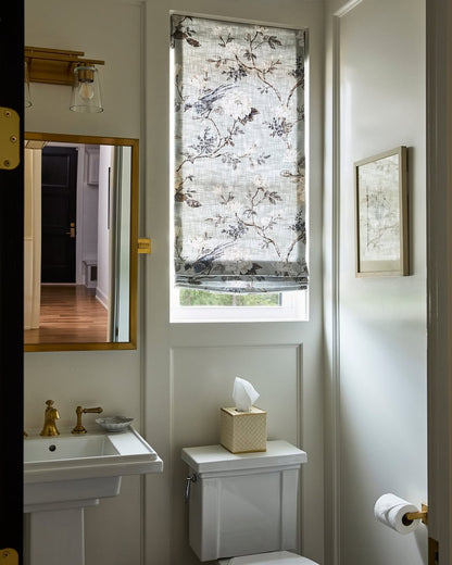Patterned fabric Roman shades with light filtering in a bathroom setting.