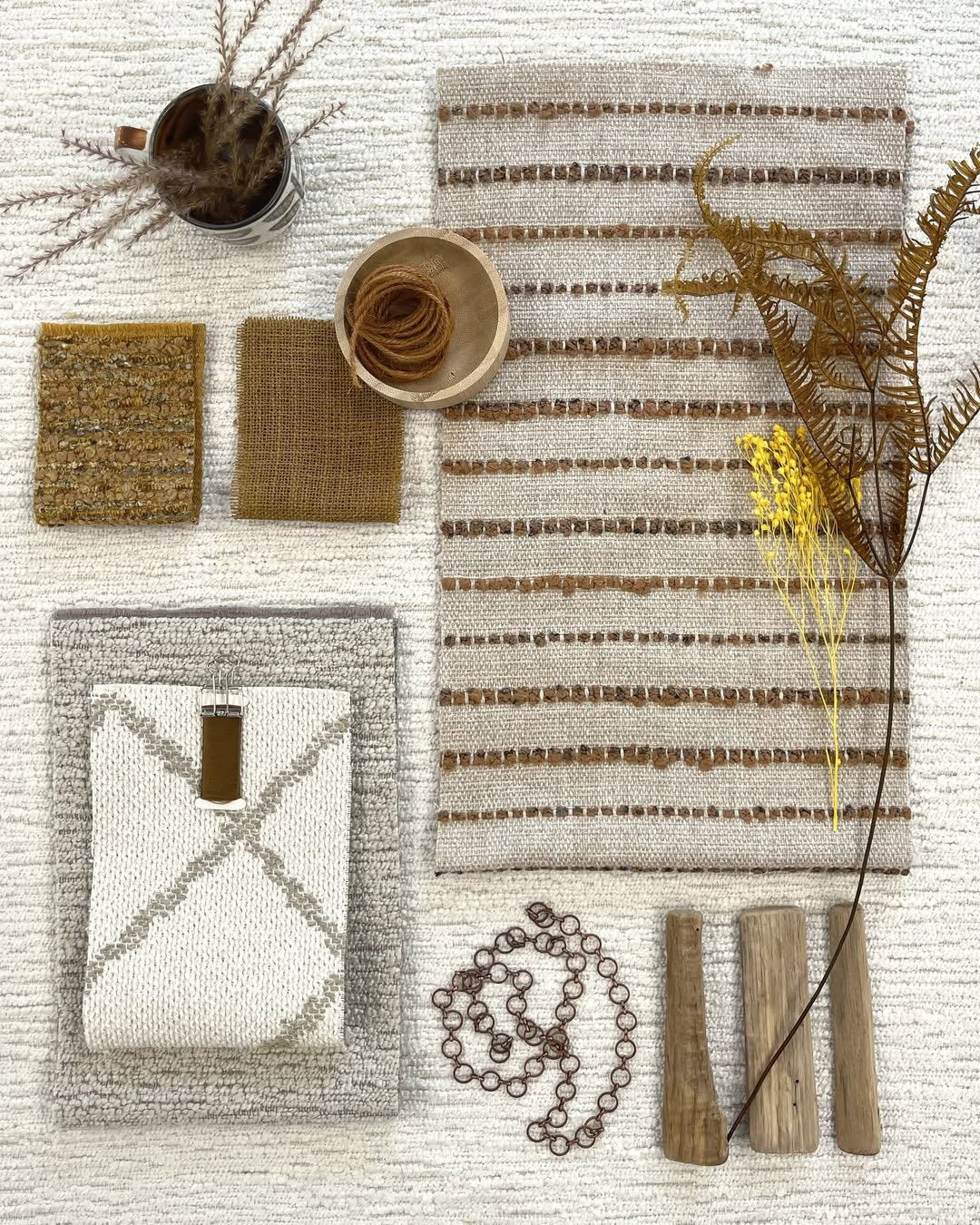Patterned fabric Roman shades in flat fold style, offering light filtering and blackout options, displayed with curated textiles and natural elements.