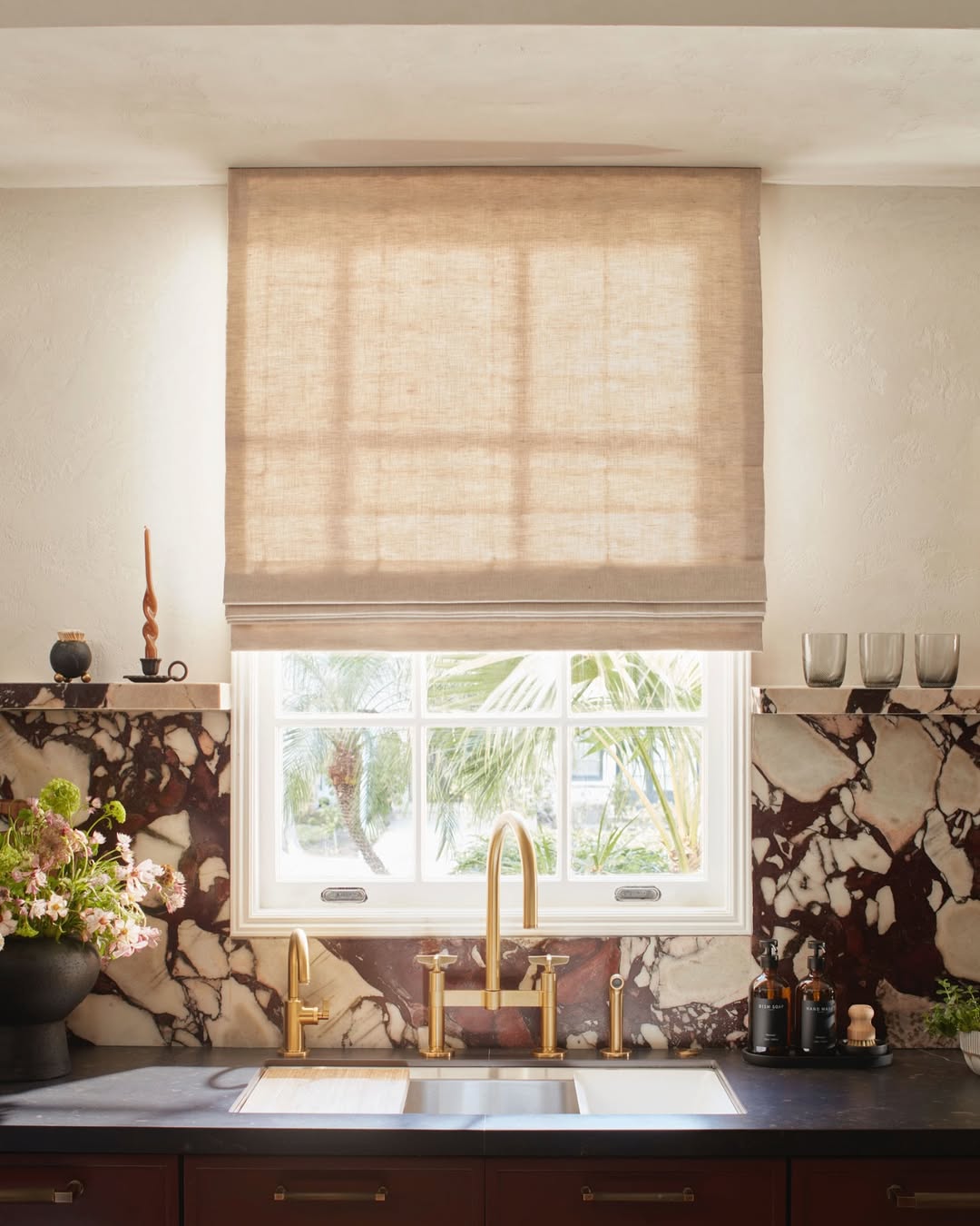 Patterned fabric Roman shades in flat fold style, light filtering and blackout options, custom fit for kitchen window.