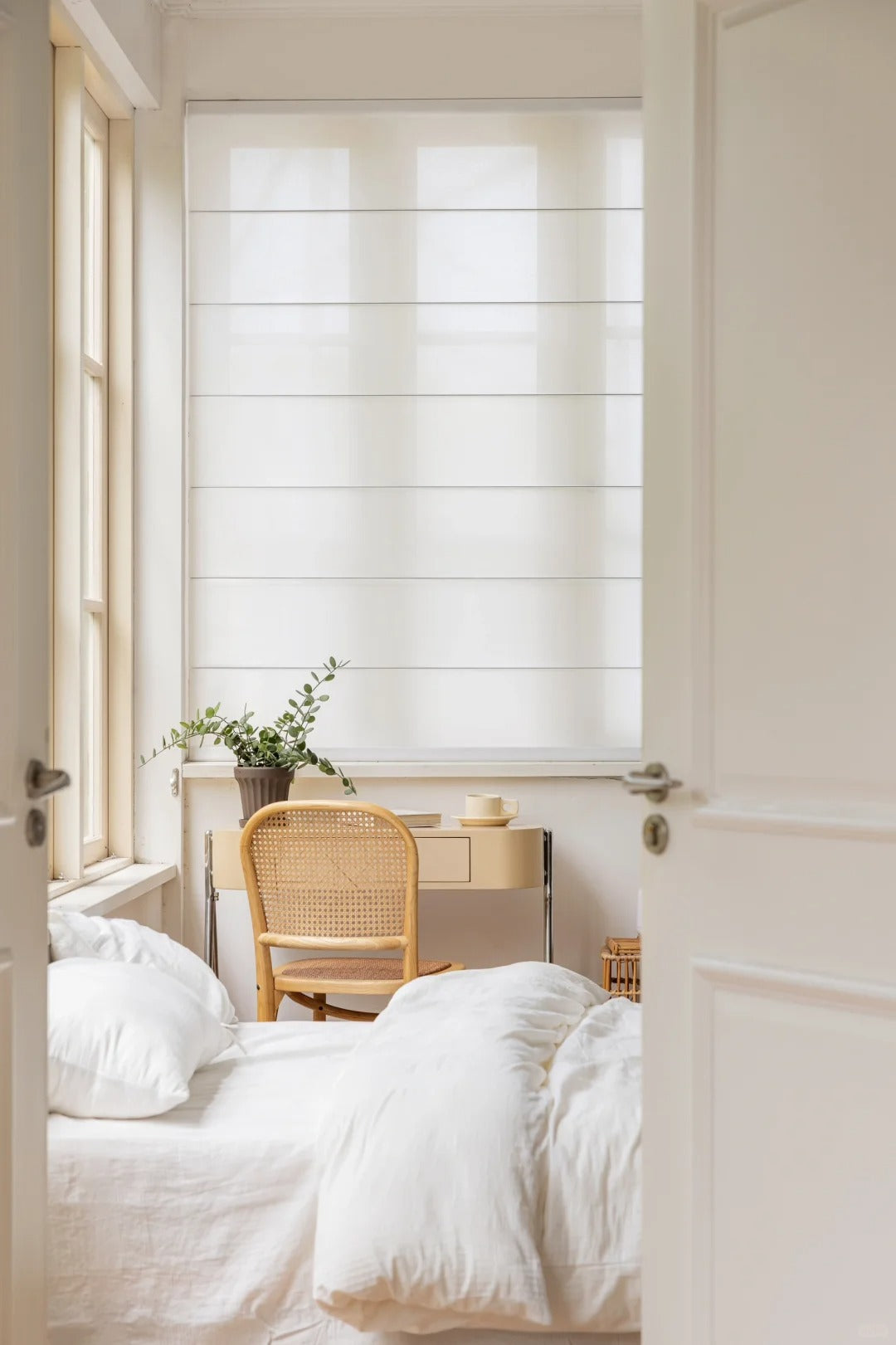 Textured semi-blackout white Roman shades with light-filtering features, shown up close.