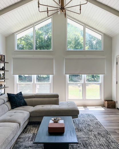 Solar shades in a modern living room, blocking sunlight, offering UV protection and privacy.