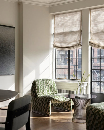Modern living room with custom relaxed Roman shades in natural linen filtering soft light through large windows