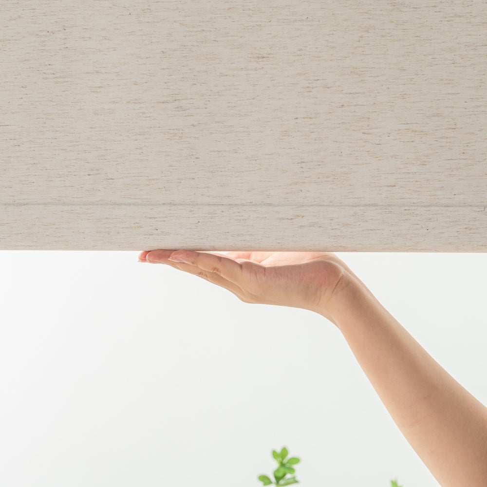 Cream-colored linen roller shades featuring a cordless design that allows for easy adjustment and stops at any position