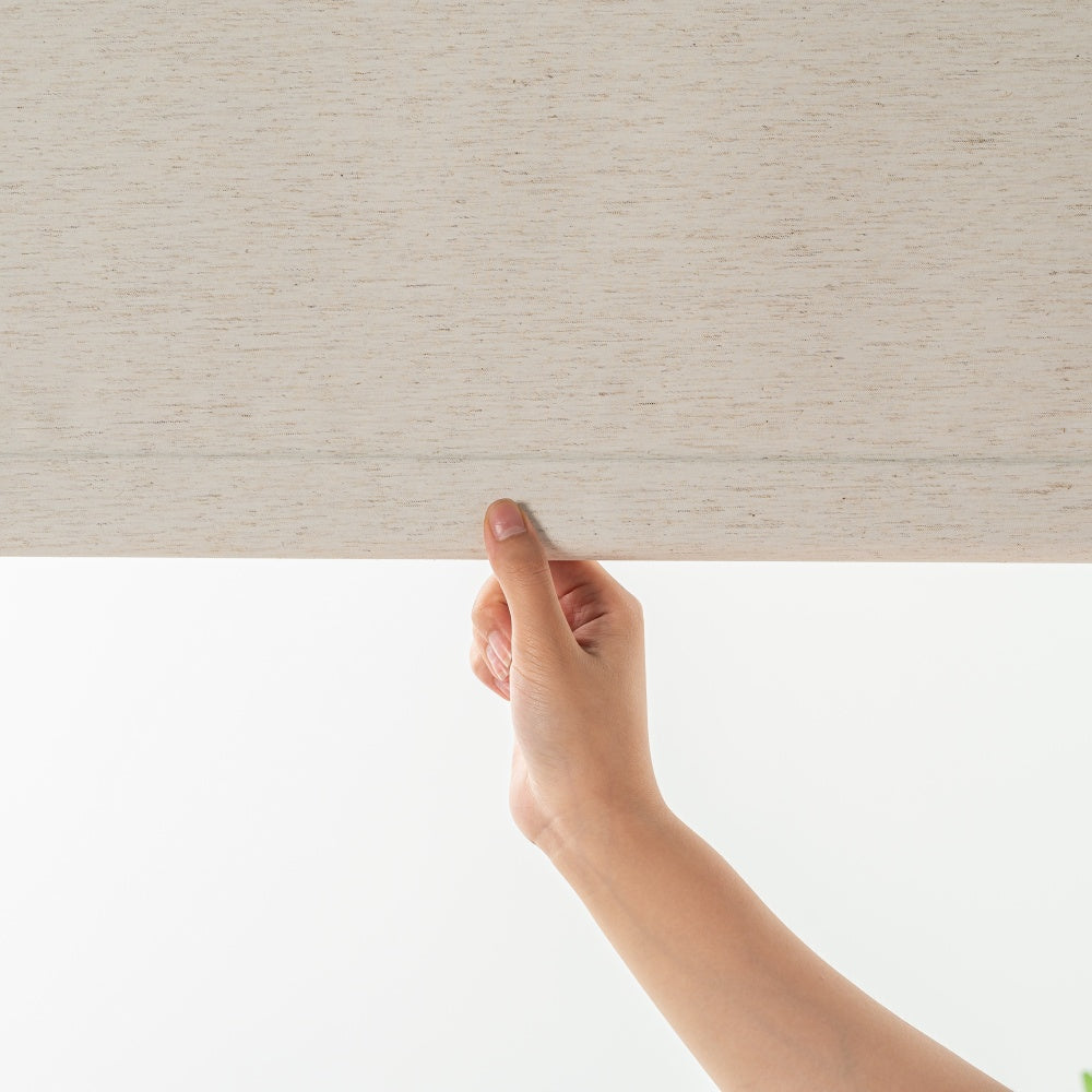 Installed cream-colored linen roller shades with a smooth texture and a convenient cordless pull-to-stop mechanism