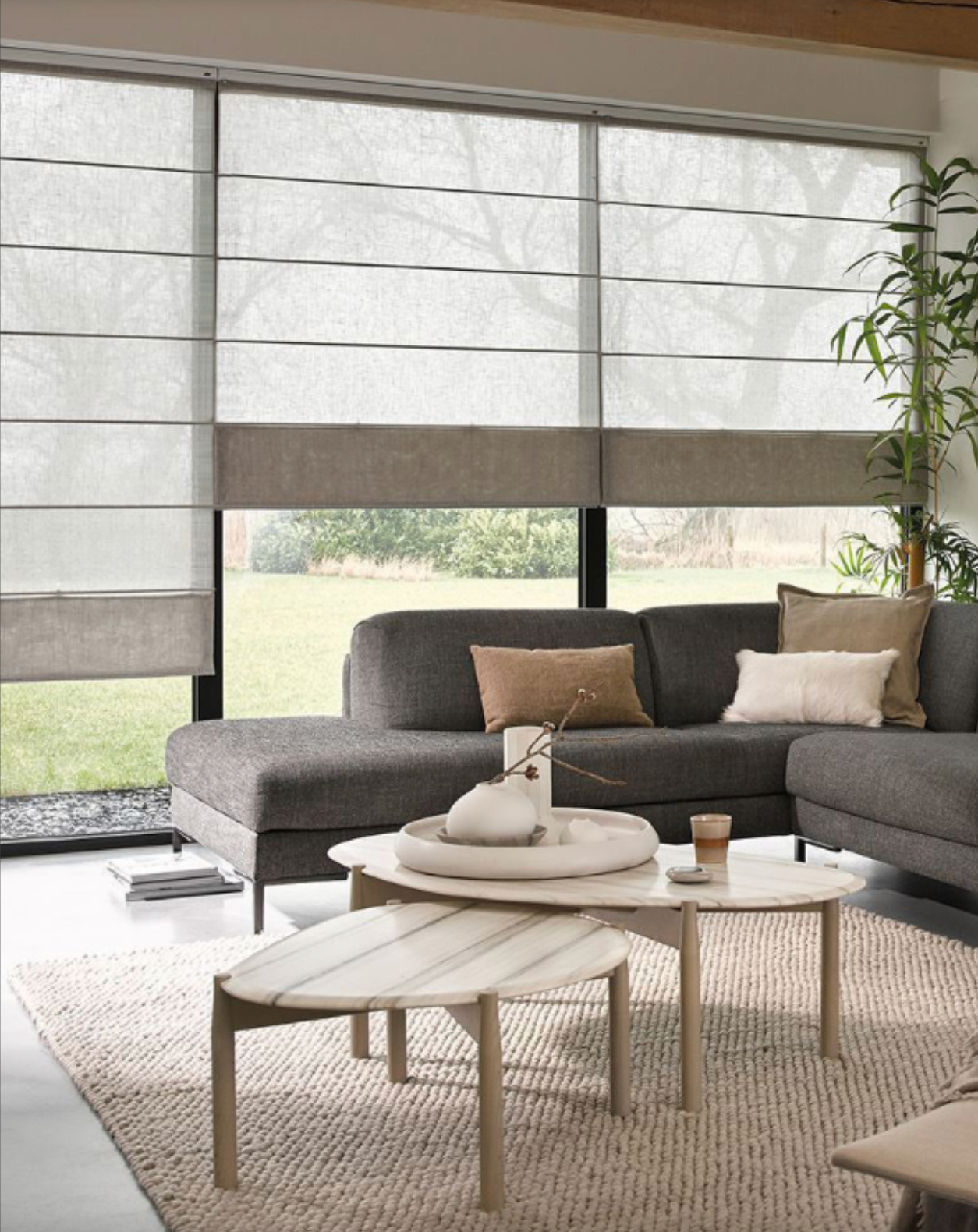 Modern living room with eco-friendly cordless sheer Roman blinds from EaseEaseCurtains, featuring a sectional sofa and white coffee tables