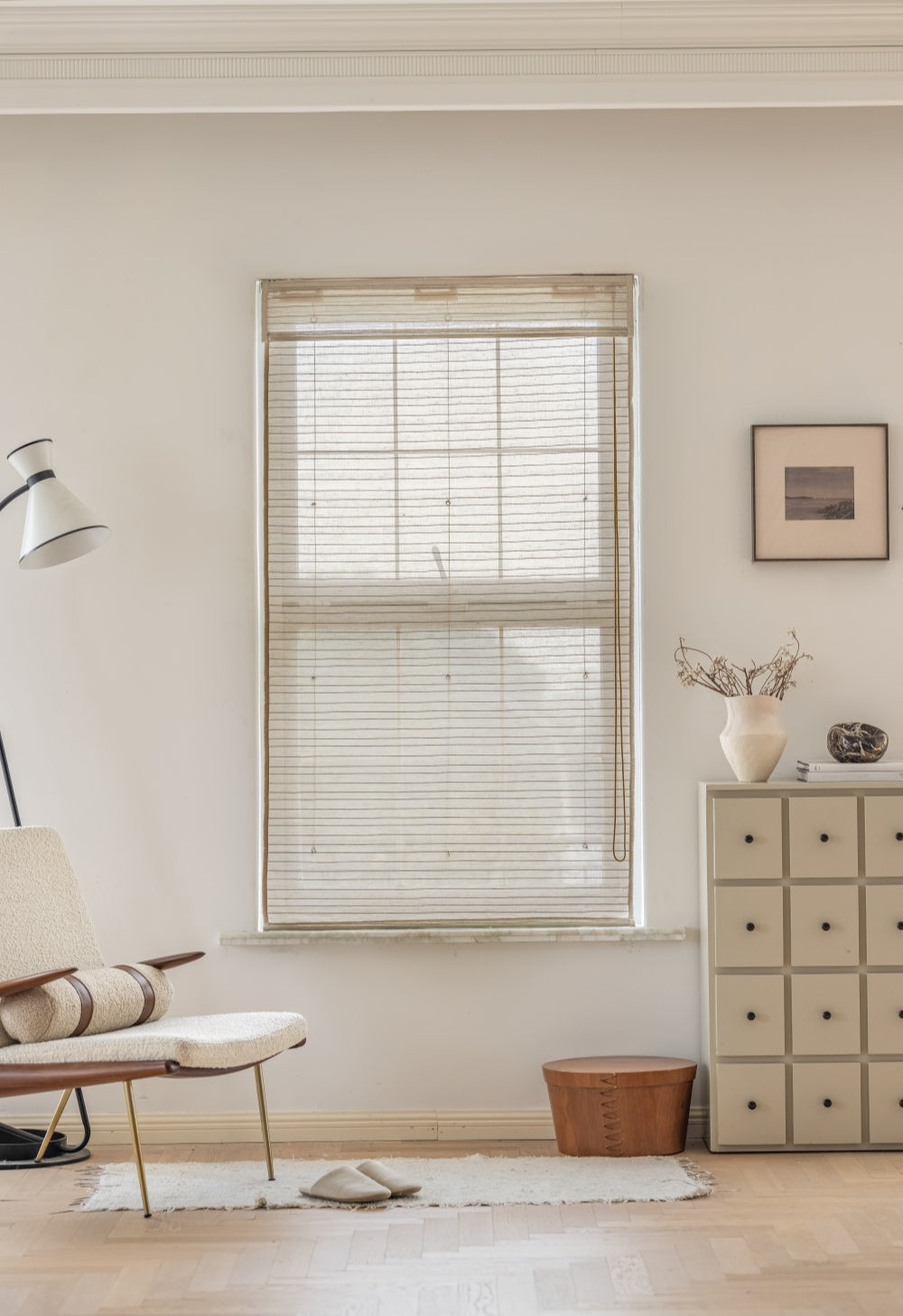 Natural linen bamboo shade with black stripes on a window, enhancing a modern interior.
