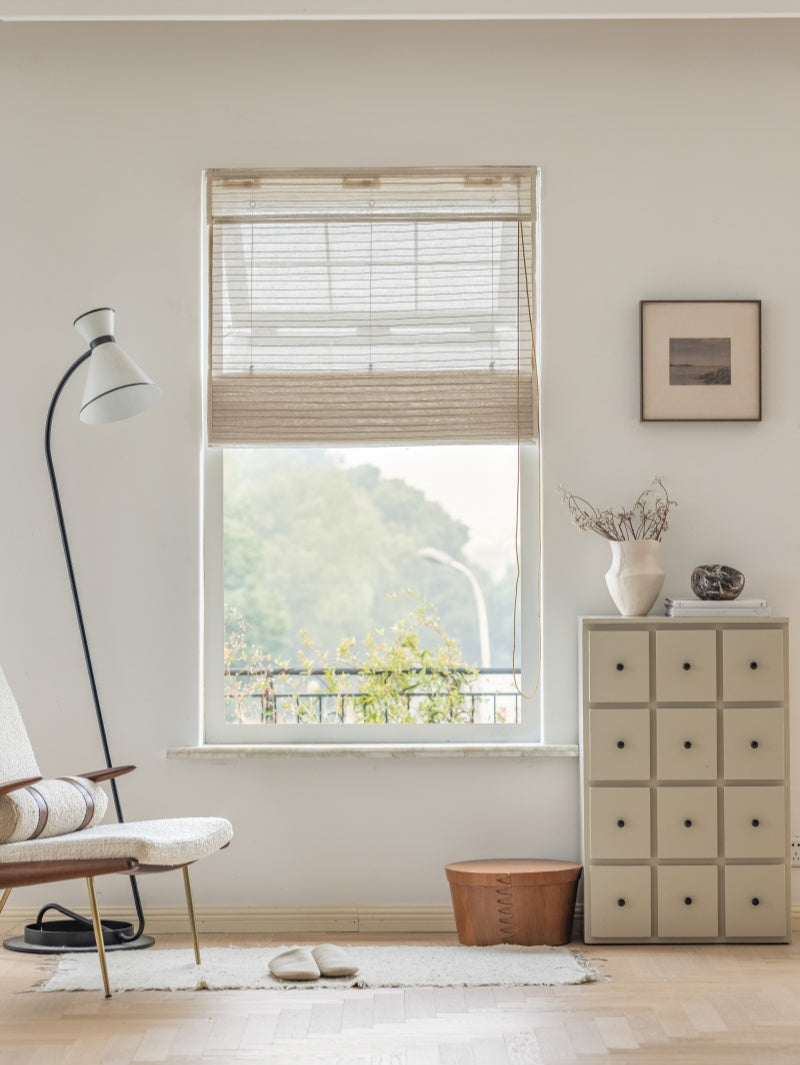 Natural linen bamboo shade with black stripes in minimalist room decor.