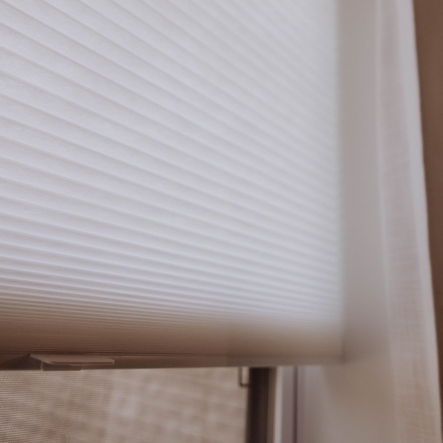Close-up of premium honeycomb cellular blind in a delicate light color, showcasing texture and pleated design, ideal for enhancing home aesthetics and functionality