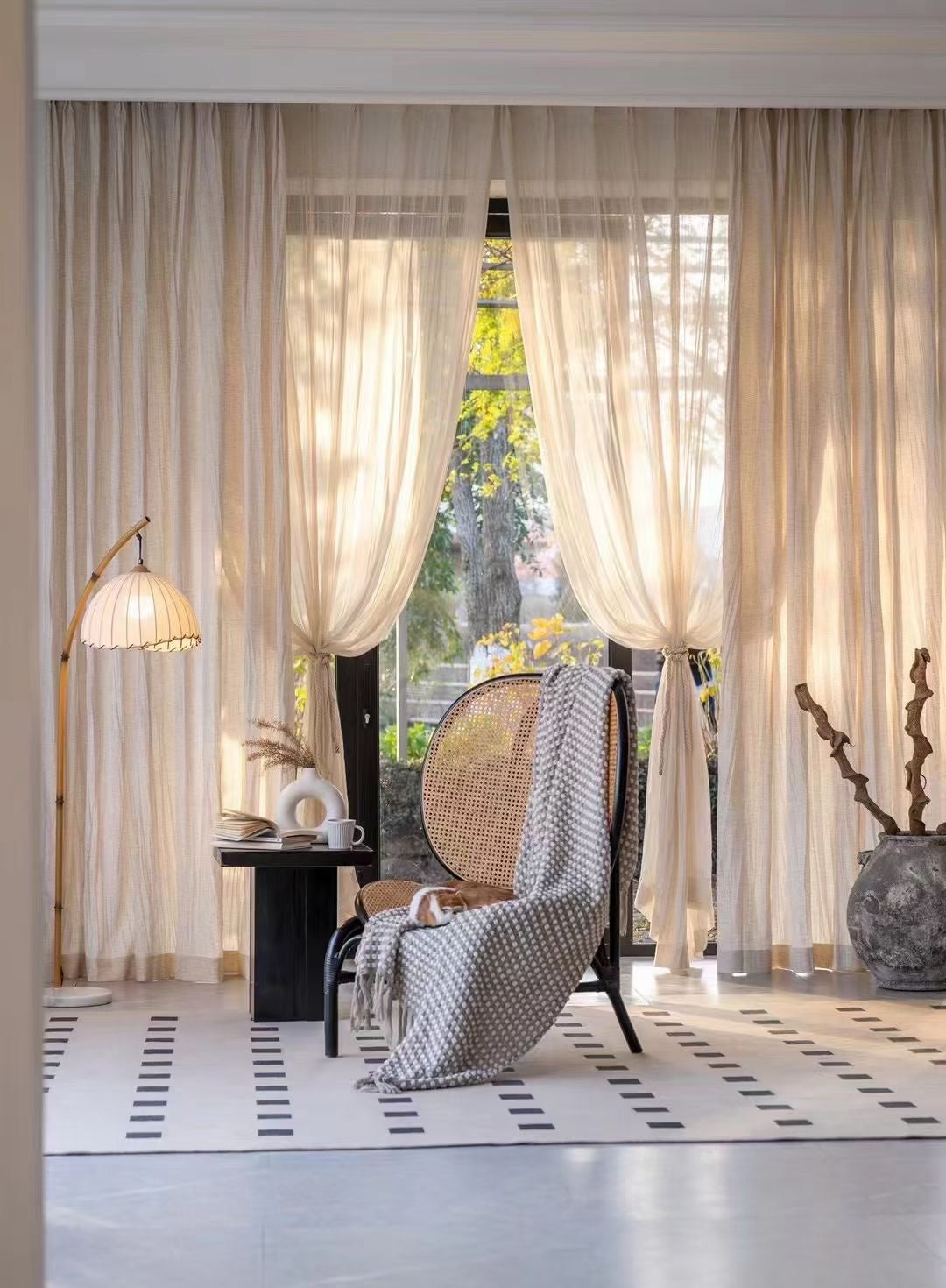 Lightweight crinkled linen gauze drapes filtering light for a breezy, airy look in a cozy room.