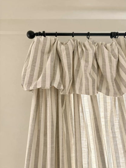 Light yellow striped linen playroom curtains hanging in a child's room with soft natural light