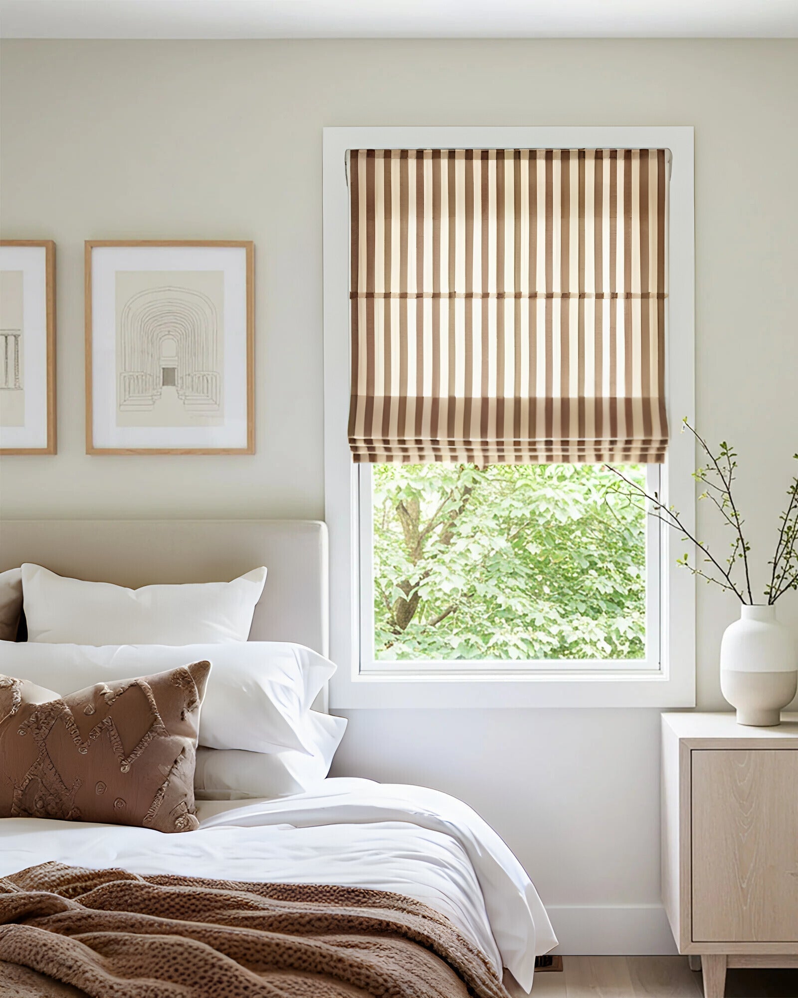 Striped Roman shades with cordless lift in a bedroom window filtering light and enhancing decor