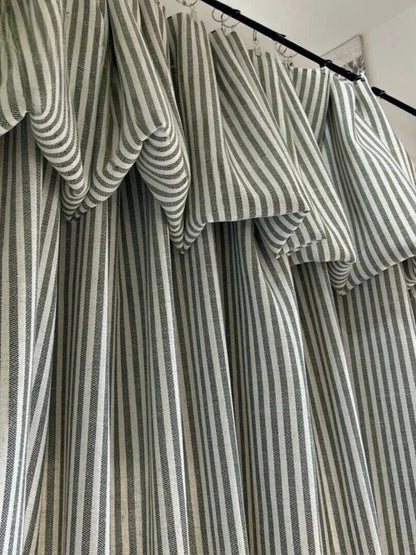 Classic linen striped curtains in neutral tones with fine and bold vertical stripes hanging on a black curtain rod