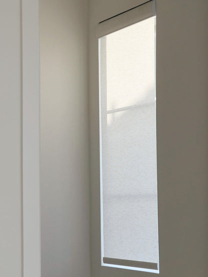 Semi-sheer linen roller shades on a balcony with sunlight streaming through, creating a warm and inviting ambiance while allowing natural light to gently filter in.