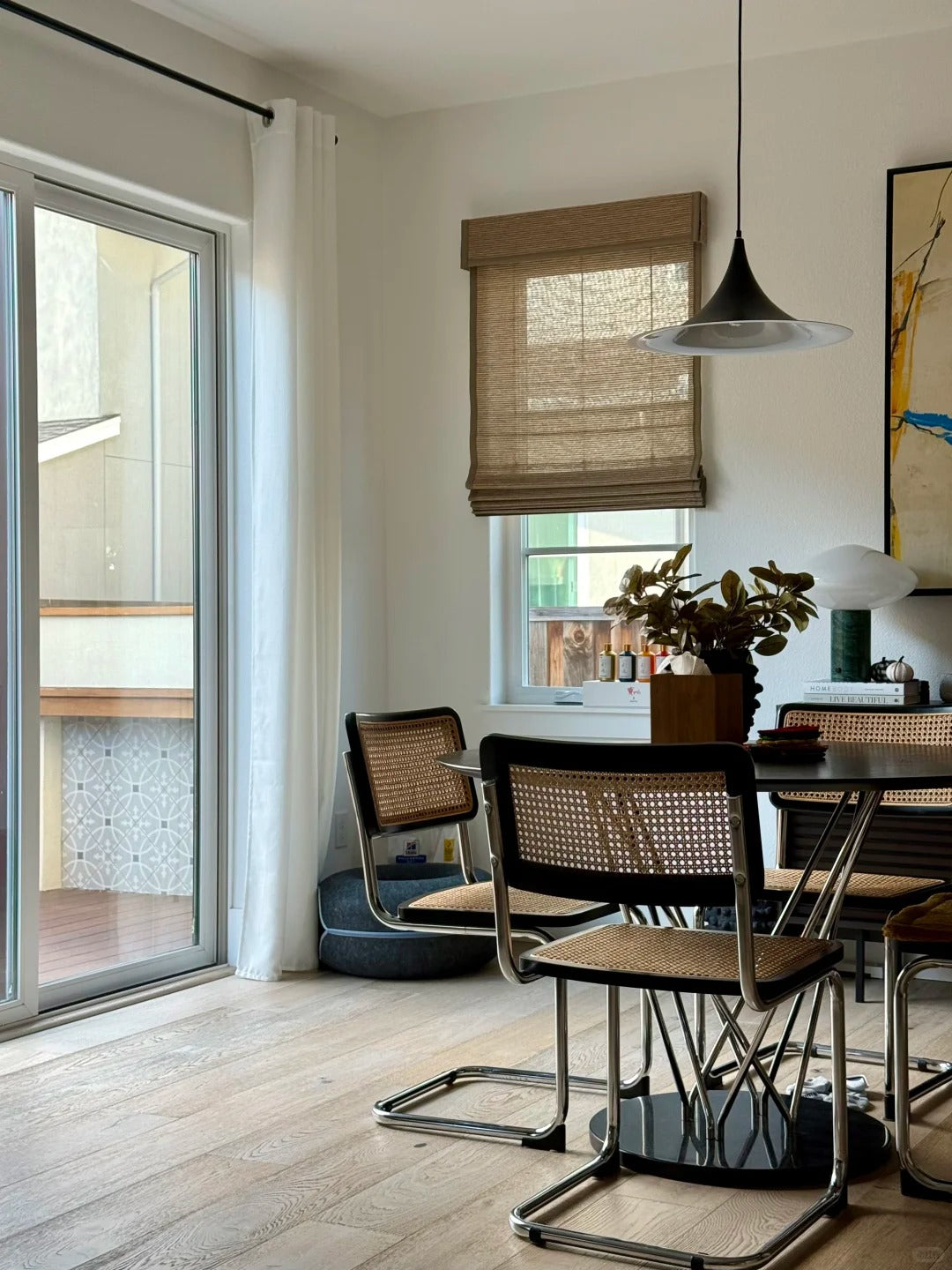 Bamboo roman shades in a dining room with woven texture filtering natural light elegantly