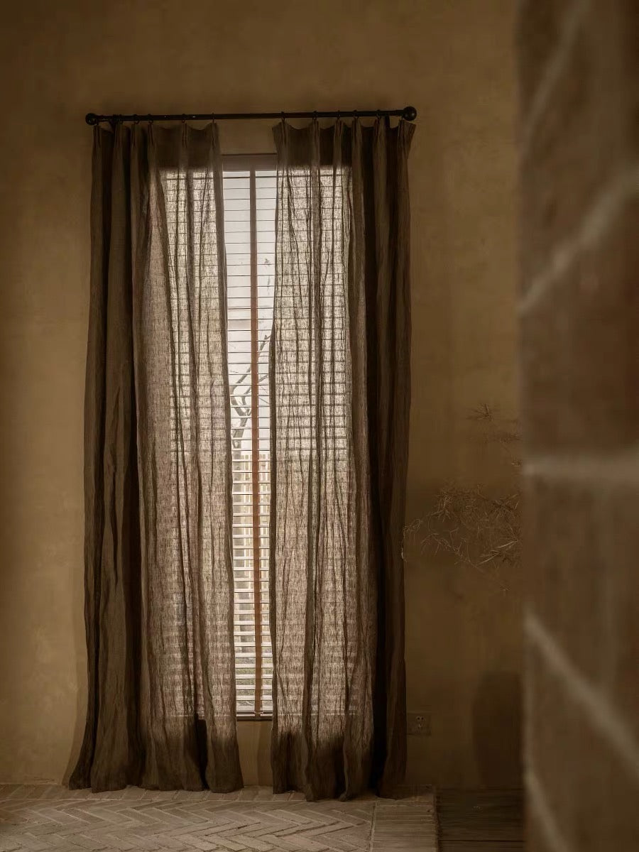 Coffee brown linen curtains in a sheer, lightly textured weave, hanging in long panels with a softly gathered finish