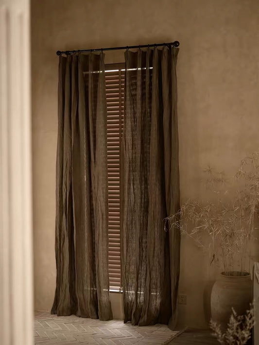 coffee brown linen curtains with a sheer, textured weave and gathered panels hanging from a dark rod