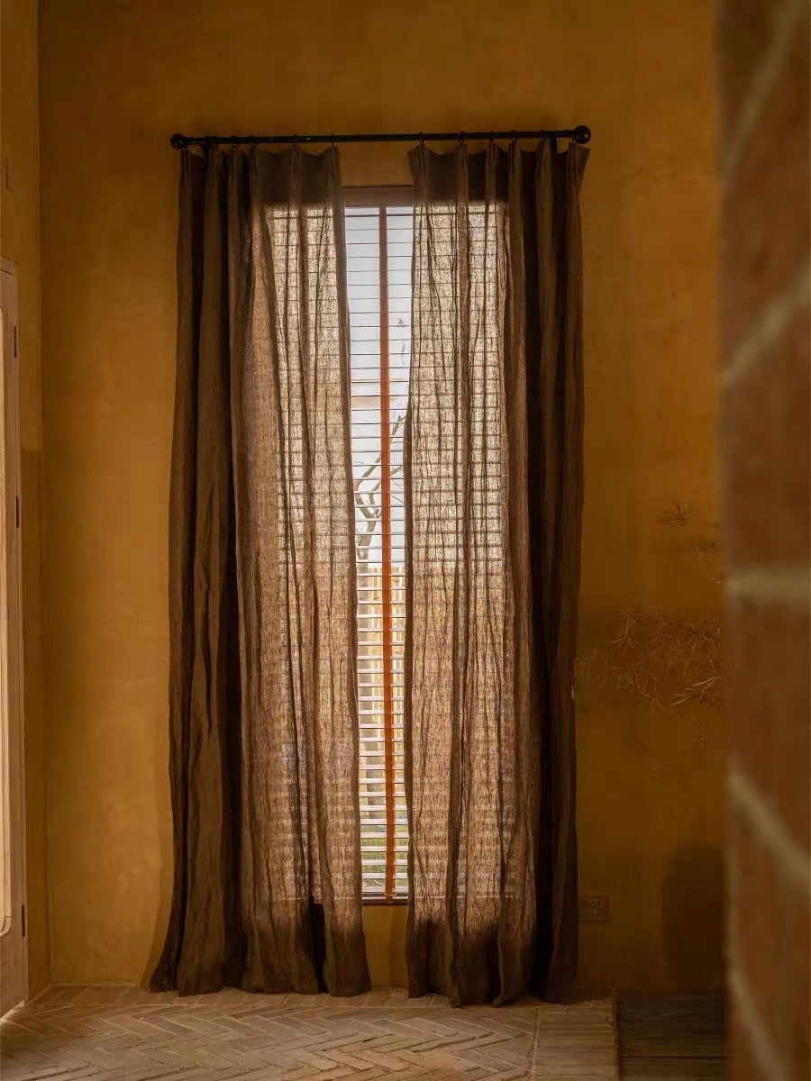 Coffee brown linen curtains with a sheer, loosely woven texture and long panels softly filtering daylight
