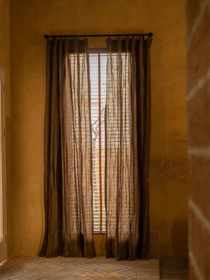 Coffee brown linen curtains with a sheer, loosely woven texture and long panels softly filtering daylight