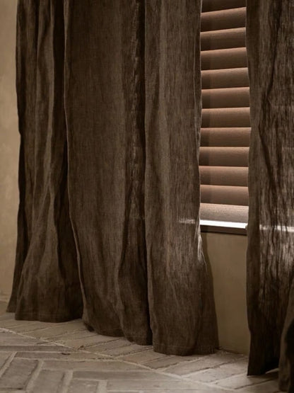Coffee brown linen curtains with a sheer, loosely woven texture and softly draping floor-length panels