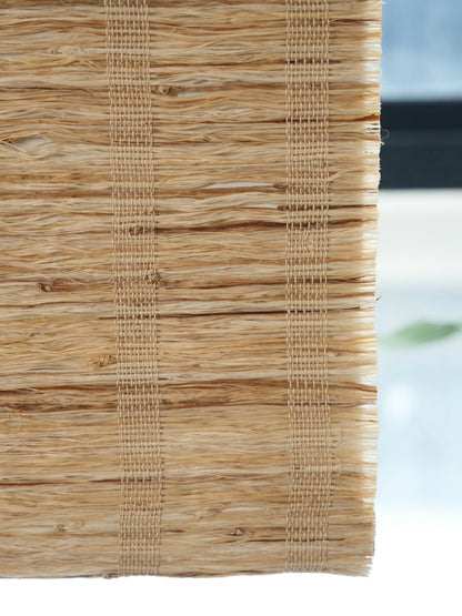 Close-up of natural cordless bamboo shades honey-toned woven shades made from 100% ramie fiber with breathable, textured weave.